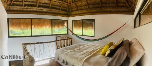 una camera con un letto in una stanza con finestre di Ca Nikte Cabañas a El Cuyo