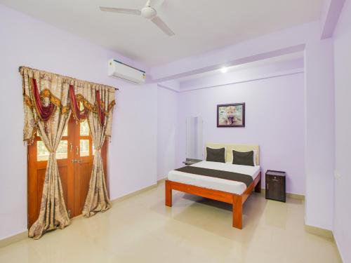 1 dormitorio con cama y ventana en Collection O Shadowline Guesthouse en Goa