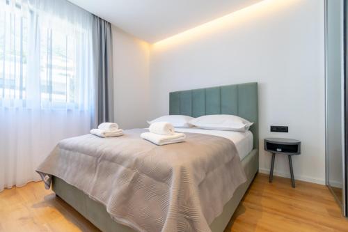 um quarto com uma cama com toalhas em Apartmani Pino 1 em Baska Voda