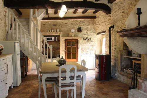 une cuisine avec une table et des chaises dans une pièce dans l'établissement Le Bastidon, gîte des Lucioles en Provence, à Montségur-sur-Lauzon