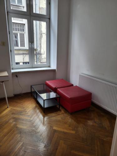 クラクフにあるAgnieszki Room nr 2のリビングルーム(赤いソファ、テーブル付)
