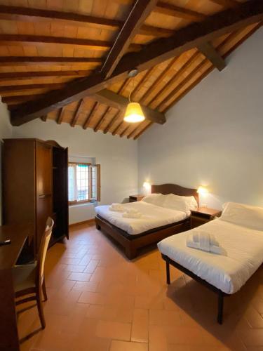 a bedroom with two beds in a room with wooden ceilings at Casale dei cento Acri in Florence