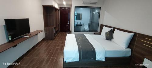a bedroom with a bed and a flat screen tv at LS HOTEl in Kim Bảng
