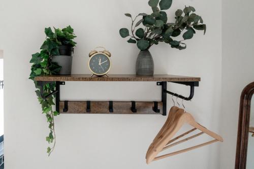 a shelf with a clock and a vase with a plant at Cardross Inn in Cardross
