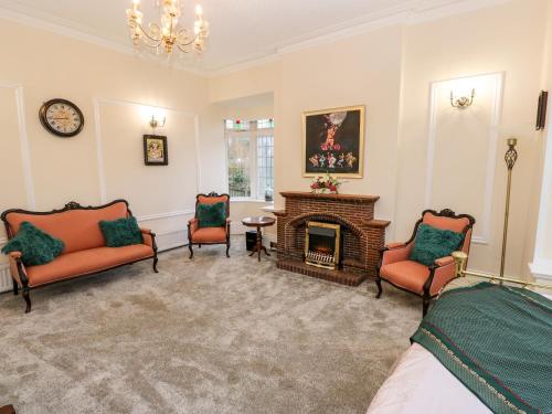 a living room with two chairs and a fireplace at Akila in Oldham