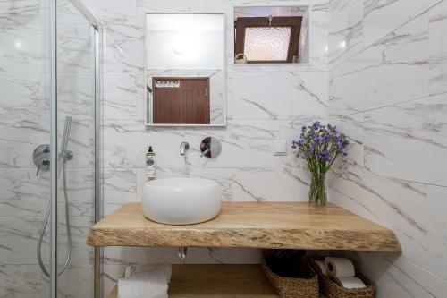 a bathroom with a sink and a glass shower at Monte do Cerro in Porto Covo