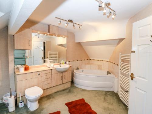a bathroom with a tub and a sink and a toilet at Akila in Oldham