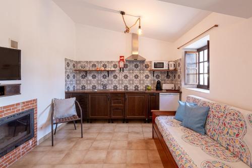 a living room with a couch and a kitchen at Monte do Cerro in Porto Covo