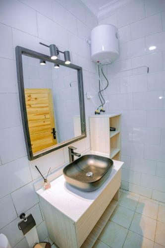 a bathroom with a black sink and a mirror at Makeri Residence - Musanze , Rwanda in Ruhengeri