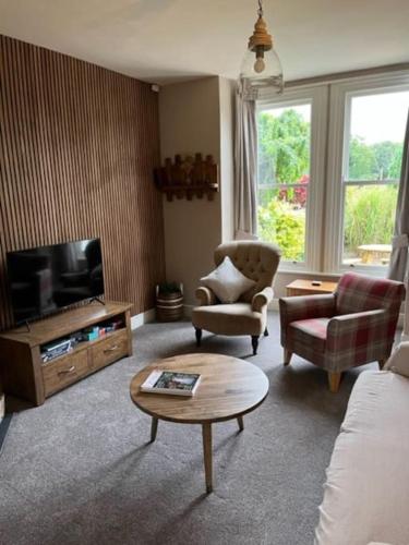 a living room with a couch and a tv at The Blue Cottage with luxurious Super King bed in Darlington