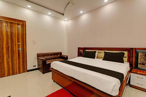 a bedroom with a large bed and a chair at OYO Awadh International in Pratāpgarh