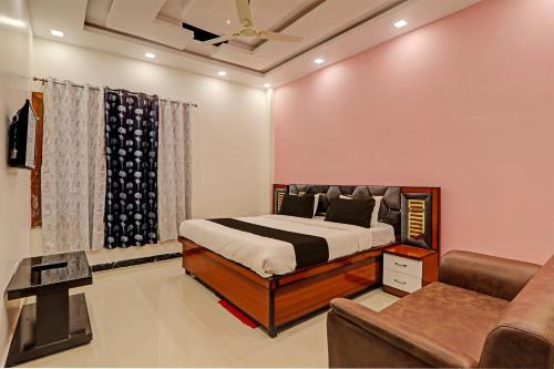 a bedroom with a bed and a couch at OYO Awadh International in Pratāpgarh