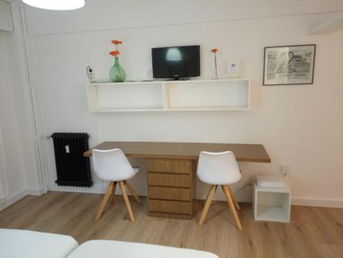 a room with a desk and two white chairs at Pelamios Catedral in Santiago de Compostela