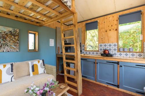 a bedroom with a bed and a ladder in a tiny house at Cabin Westerlands in Selham