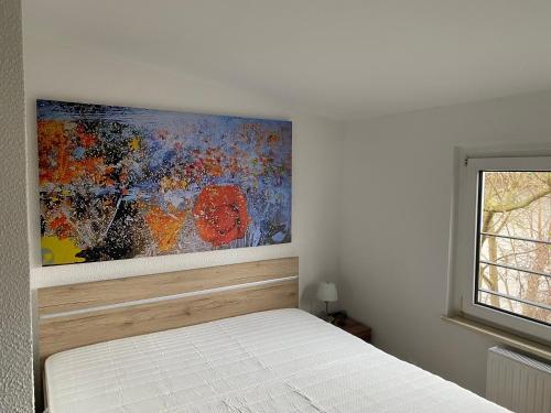 um quarto com uma cama com um quadro na parede em Haus Heiken em Altemburgo