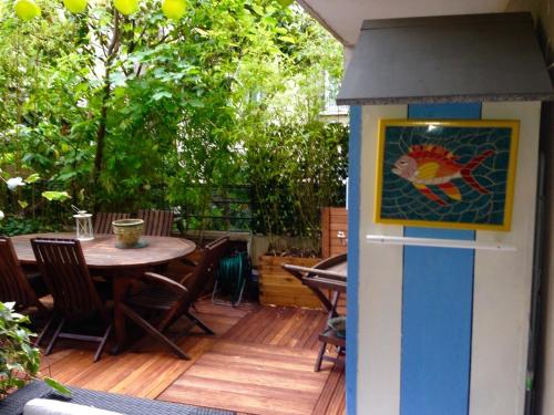 Casa de aves colorida en un patio con mesa en Paris Central Design Jardin & Terrasse privé, en París