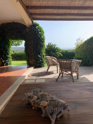 a pile of shells on a patio with a table and bench at Lulamax Sardegna in Budoni