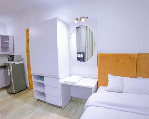 a bedroom with a bed and a desk and a mirror at Makeri Residence - Musanze , Rwanda in Ruhengeri