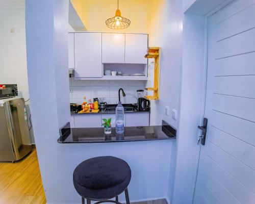 a kitchen with a black stool and a sink at Makeri Residence - Musanze , Rwanda in Ruhengeri