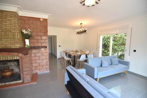 a living room with a fireplace and a blue couch at RNET - MT - Casa Can Carles in Roses