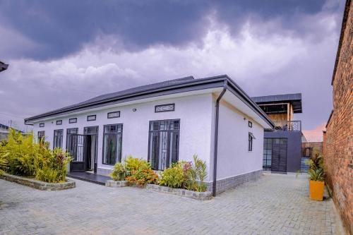 a white building with plants in a courtyard at Makeri Residence - Musanze , Rwanda in Ruhengeri