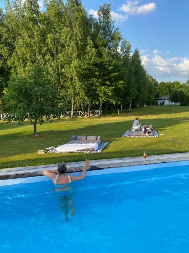 a woman in a swimming pool in a park at Farma Bii in Brzeziny