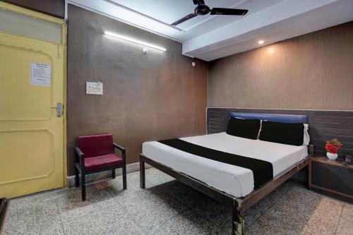 ein Schlafzimmer mit einem Bett und einem roten Stuhl in der Unterkunft SPOT ON Hotel Drip Inn in Lucknow