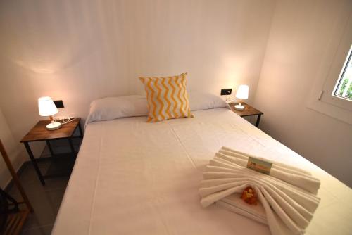 a bedroom with a white bed with two side tables at RNET - MT - Casa Can Carles in Roses