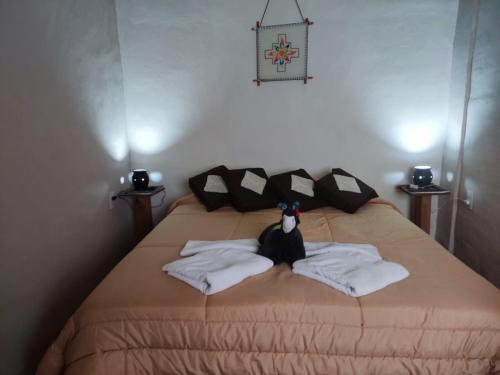 łóżko z pluszakiem siedzącym na nim w obiekcie Retama w mieście Tilcara