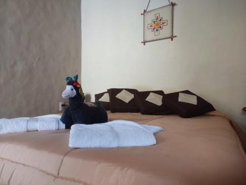 a bed with a stuffed animal on top of it at Retama in Tilcara