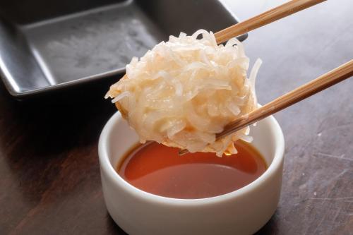 a piece of rice in a bowl of sauce at 奥武雄温泉　風の森 in Ureshino