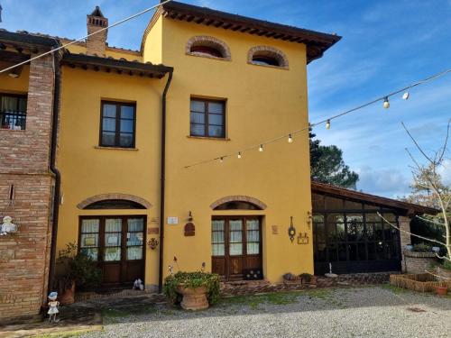 ein gelbes Haus mit einer Reihe von Lichtern in der Unterkunft Tenuta Il Casale di San Miniato in San Miniato