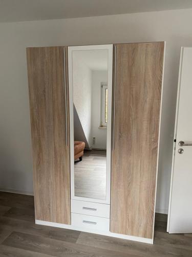 a large mirror with wooden doors in a room at Haus Heiken in Altenburg