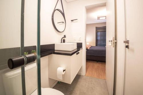 a bathroom with a sink and a mirror at Apto 617 com vista Parque Una in Pelotas
