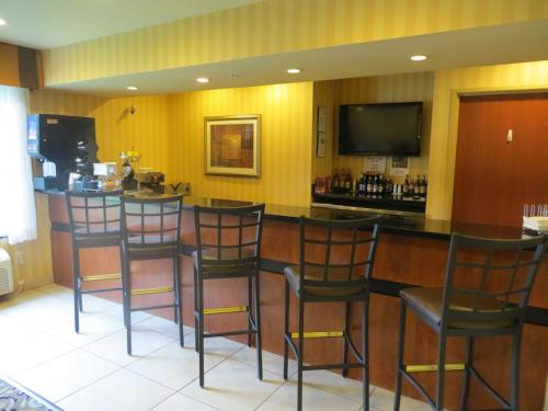 a bar in a restaurant with chairs and a television at Cobblestone Inn & Suites - Brillion in Brillion