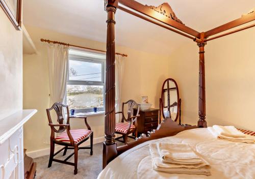 een slaapkamer met een hemelbed en een bureau bij Gardenwell Cottage in Hawes