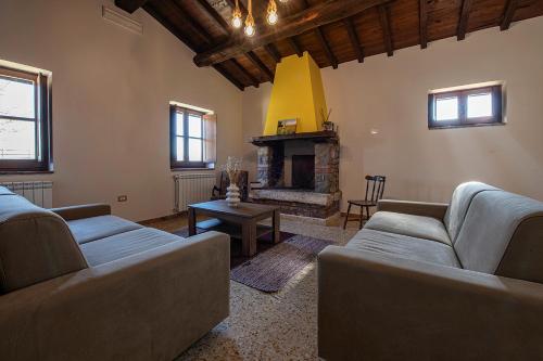 a living room with two couches and a fireplace at Il casale del Mignone in Blera