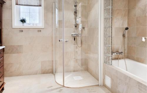 a shower with a glass door in a bathroom at 4 Bedroom Gorgeous Home In Lyngdal in Lyngdal