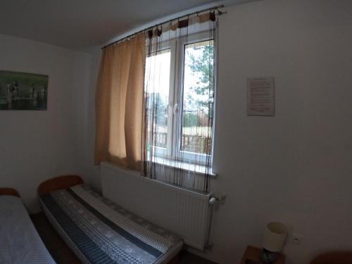 um quarto com uma cama e uma janela em noclegi u Adama em Kajetany