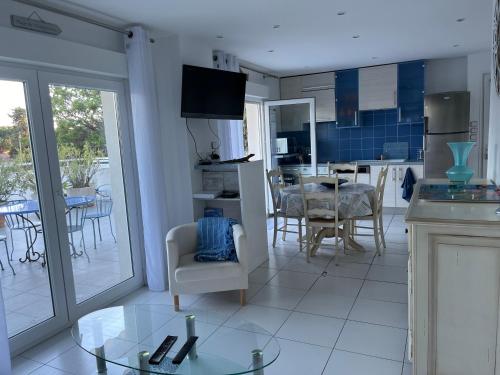 une cuisine et une salle à manger avec une table et des chaises dans l'établissement RDC GRANDE TERRASSE à 200m de la plage au calme, à Cavalaire-sur-Mer