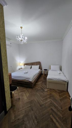 a bedroom with two beds and a chandelier at Guest House Tbilisi style in Tbilisi City