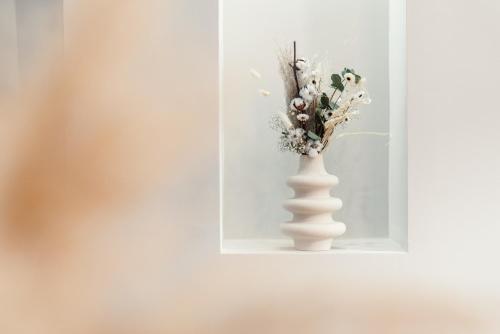a white vase with flowers in a niche in a wall at NEW LUXUS Suite I TWO Kingbeds I Center in Augsburg