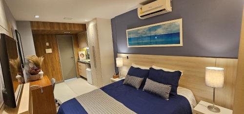 a bedroom with a bed with blue sheets and pillows at Option Full Service Residence in Rio de Janeiro