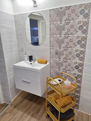 a bathroom with a white sink and a mirror at Várfal apartman in Eger