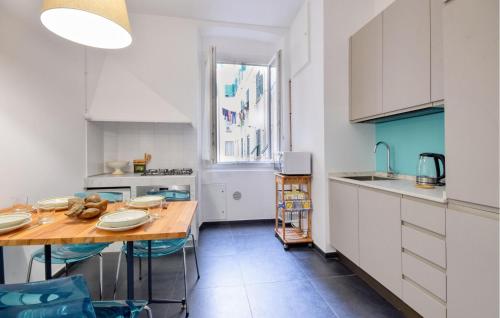 kuchnia z białymi szafkami i drewnianym stołem w obiekcie Amazing Apartment In Genova With Wifi w Genui
