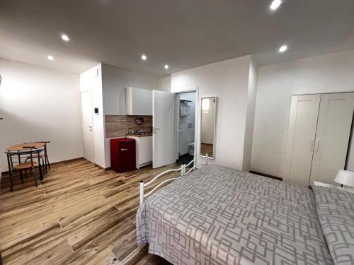 a bedroom with a bed and a table and a kitchen at Paolessi House in Rieti