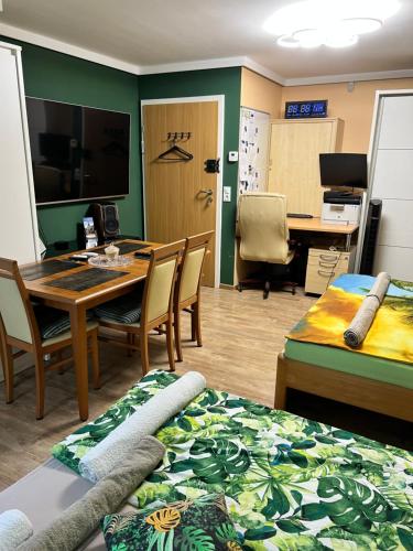 a room with a table and chairs and a desk at Ratuszowa Noclegi in Szczawno-Zdrój
