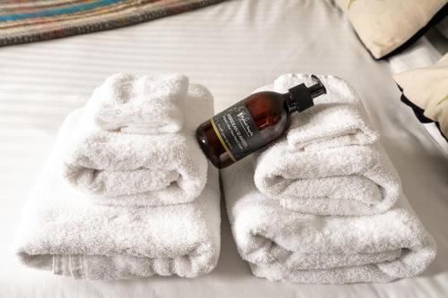 a pair of white towels with a bottle of alcohol at Cardross Inn 