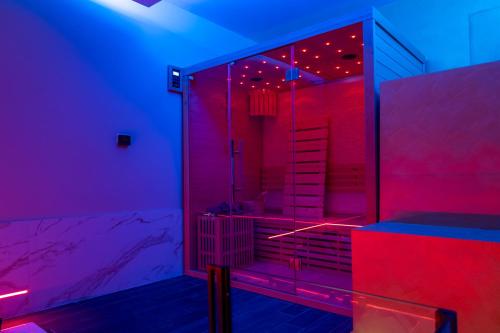 W łazience znajduje się prysznic z czerwonymi i niebieskimi światłami. w obiekcie AETERNA SUITES SPA Apartment w mieście Terracina