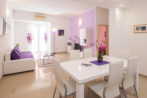 un soggiorno con tavolo e sedie bianchi di Apartment with private swimming pool a Podstrana